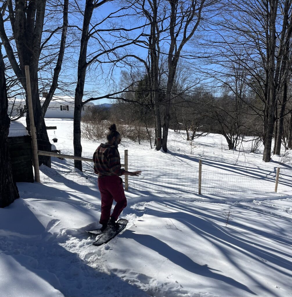Jem walks downhill in snowshoes